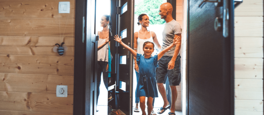 Young family of three walking in to a guest room